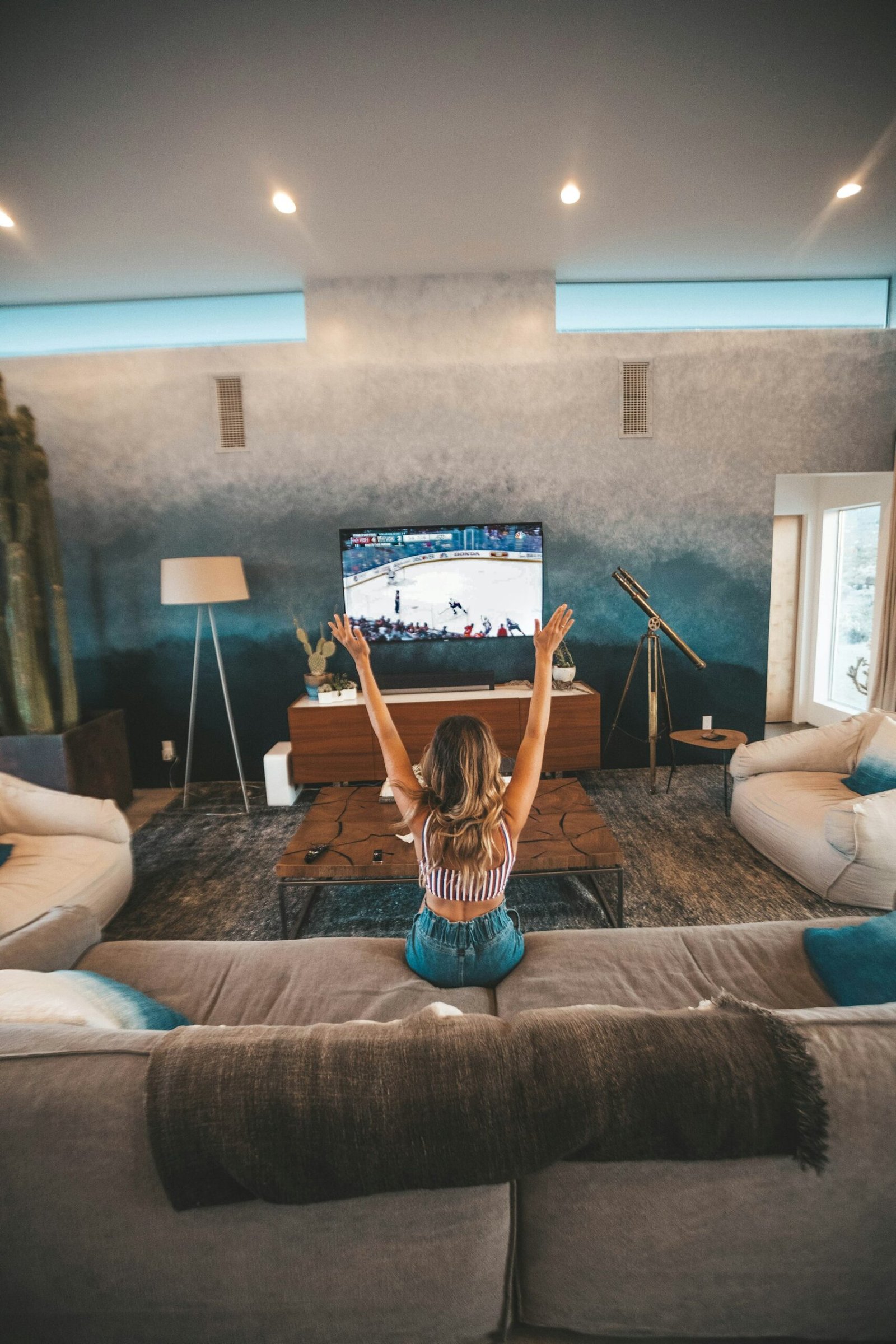 Personne assise sur un canapé devant la télévision